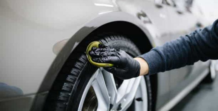 A man cleaning car with microfiber cloth, car detailing (or valeting) concept.